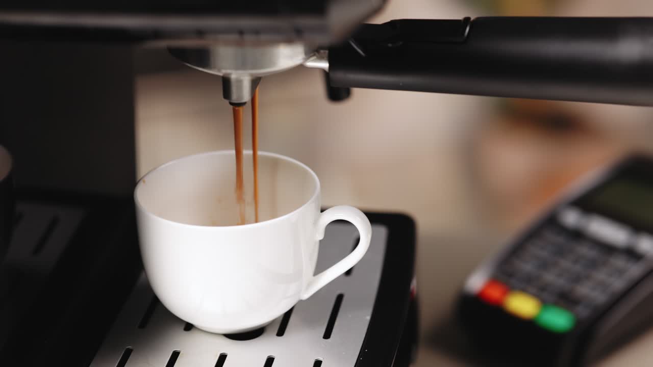 hacer una taza de café fuerte en una máquina de café. transacción de crédito al cliente haciendo pago sin contacto en cafetería, tecnología nfc. verter corriente de café de la máquina en taza blanca