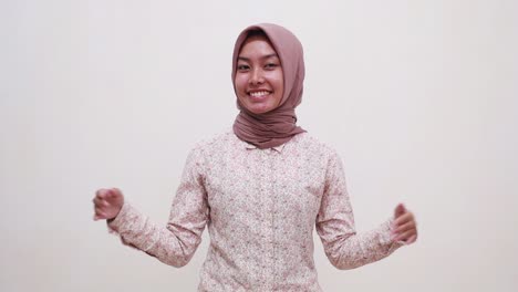 happy young asian muslim girl standing while presenting both sides