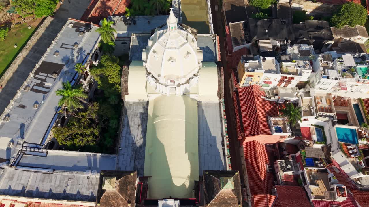 Slow motion aerial view of the cartagena cathedral dome rotating, revealing the surrounding cityscape and the caribbean sea