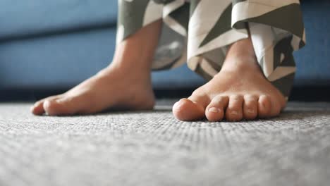 barefoot person sitting on a carpet