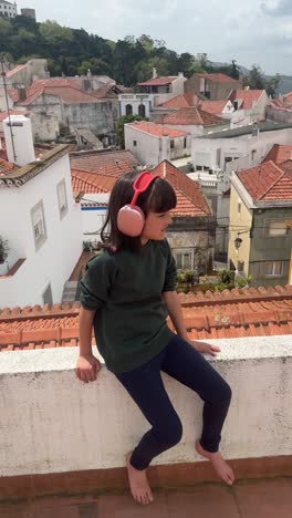girl with headphones on a rooftop in portugal