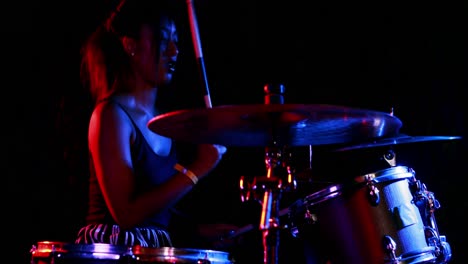 batería femenina tocando en un conjunto de tambores 4k