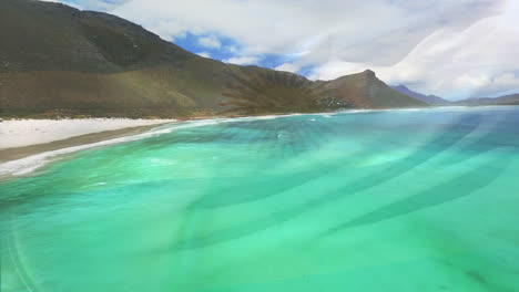 Digital-composition-of-waving-argentina-flag-against-aerial-view-of-the-beach