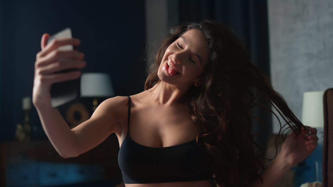 donna che si fa un selfie con il cellulare in camera da letto