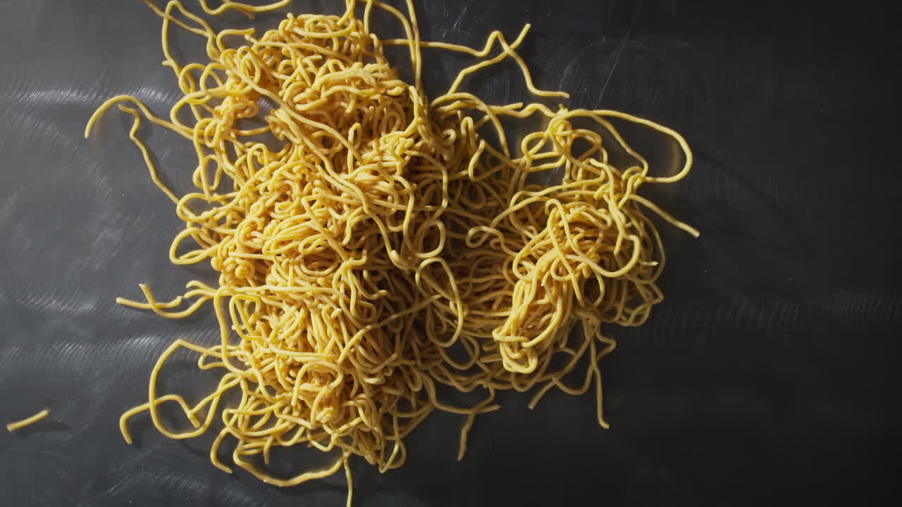 Spaghetti che cadono sul tavolo al rallentatore.