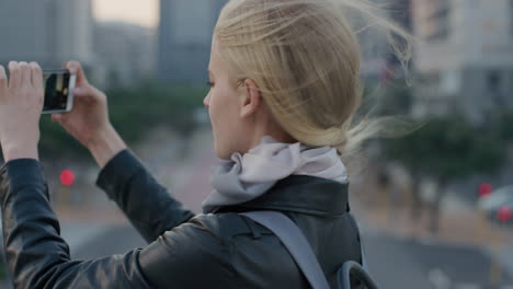 portrait young blonde woman tourist using smartphone taking photos of city photographing urban cityscape enjoying sharing travel experience smiling happy