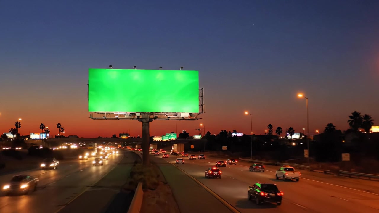 Escenas Nocturnas y Crepusculares de una Valla Publicitaria Verde Junto a una Autopista Concurrida, Capturando la Transición del Anochecer a la Noche con Luces de la Ciudad y Tráfico Activo