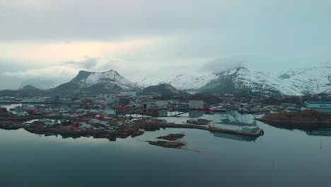 aerial drone shot of a foggy ocean in lofoten norway. with rocks and mountains in the background.