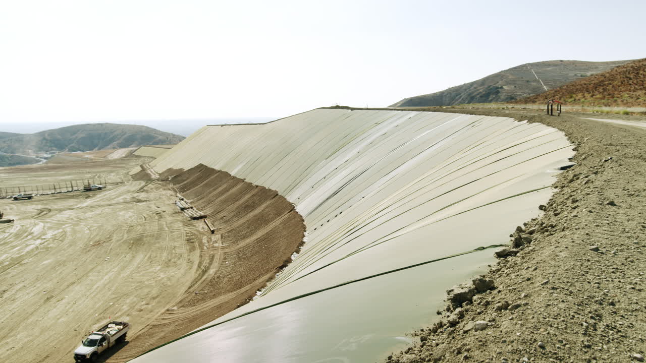 Large-scale landfill or industrial site with a geomembrane-lined slope