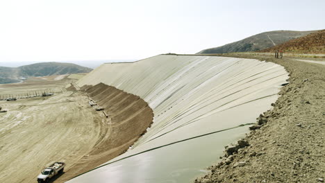 large-scale landfill or industrial site with a geomembrane-lined slope