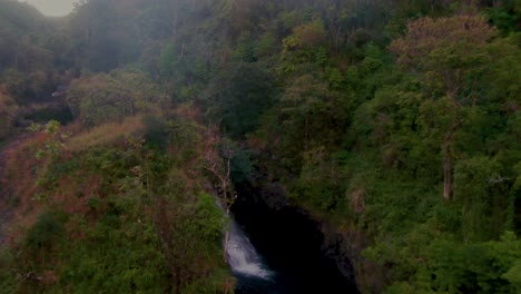 Aerial-flying-towards-Hanawi-Falls-on-cloudy-day,-Maui,-Hawaii,-USA