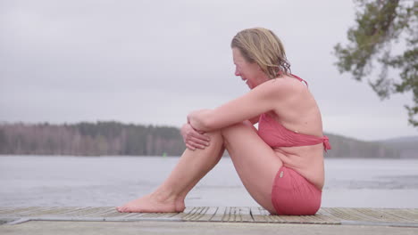 Una-Mujer-Emocional-En-Traje-De-Baño-Sentada-En-Un-Pontón-Llora-Después-De-Una-Inmersión-En-Agua-Fría