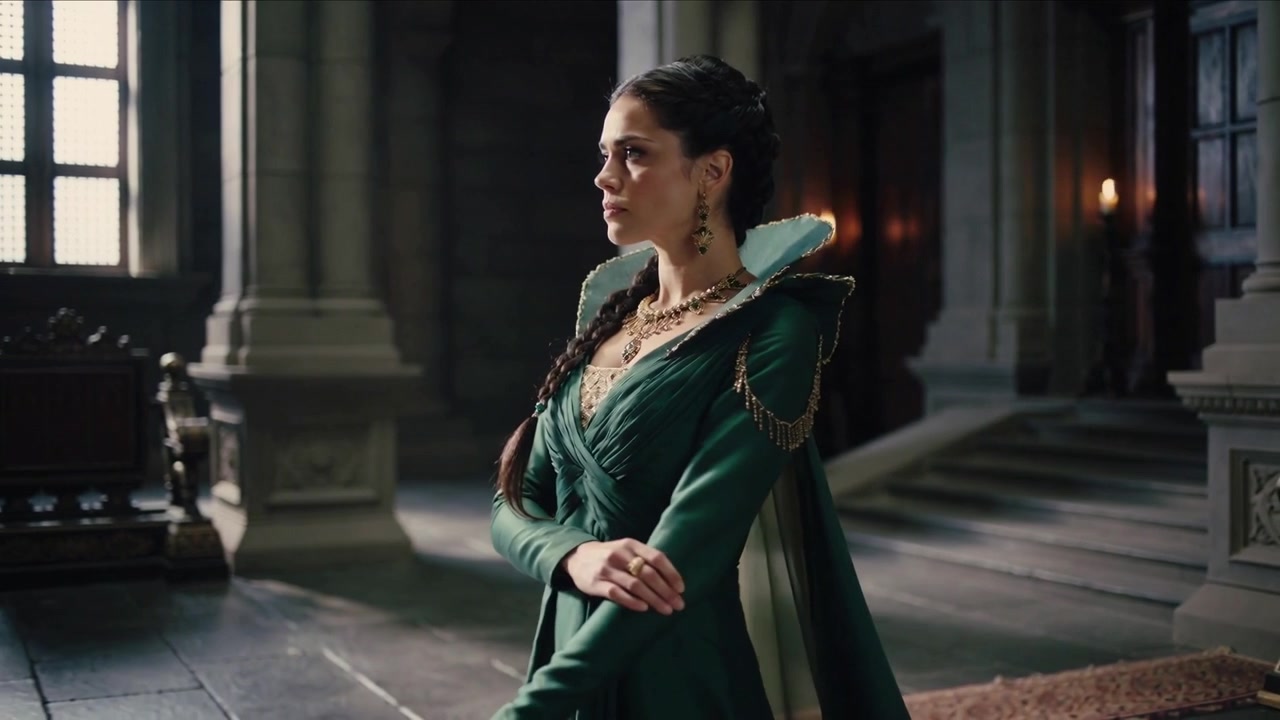 Stepping noblewoman in green gown adjusting sleeves, turning toward left window in hall with throne