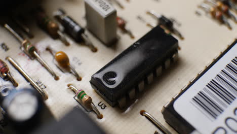 an ic integrated circuit chip along with many other electronic components on a dusty old computer board