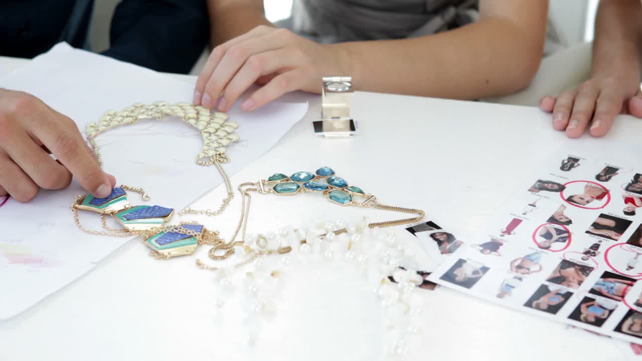 디자인 팀이 의상 보석을 보고 이야기하고 있습니다.