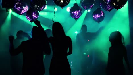 people dancing at a nightclub with disco balls