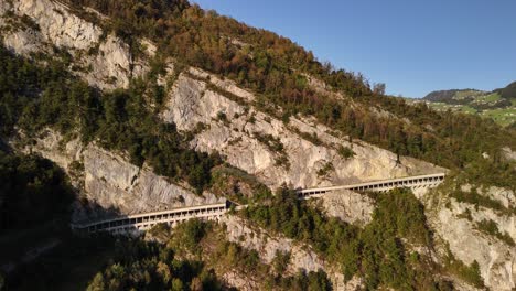 aerial view of a winding mountain road cut into a cliffside
