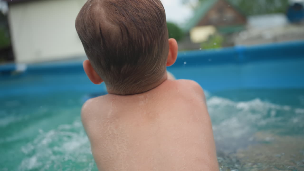 Caucasian Kids Piggybacking In Backyard Pool, Older Sister Carrying Little Brother On Her Back While They Laugh And Splash, Energetic Summer Play With Rustic Homes In Background, Carefree Sibling