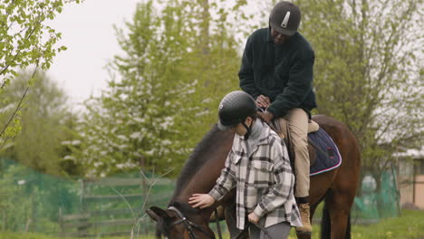 man riding a borwn horse outdoors 1