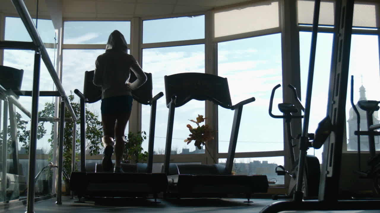 Attractive Woman Running On Treadmill In Sport Gym