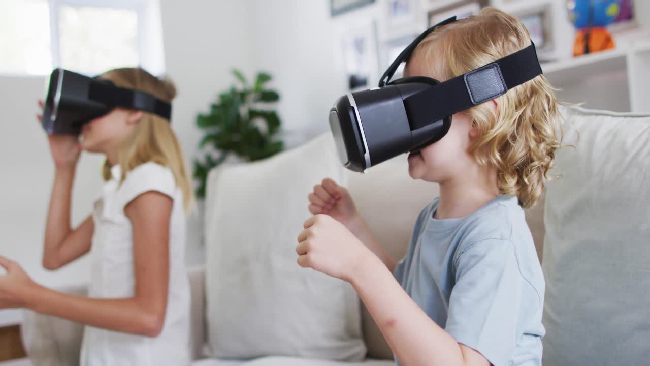 카우카시안 형제 자매가 집에서 소파에 앉아 vr 헤드 ⁇ 을 사용하면서 몸짓을 하고 있습니다.