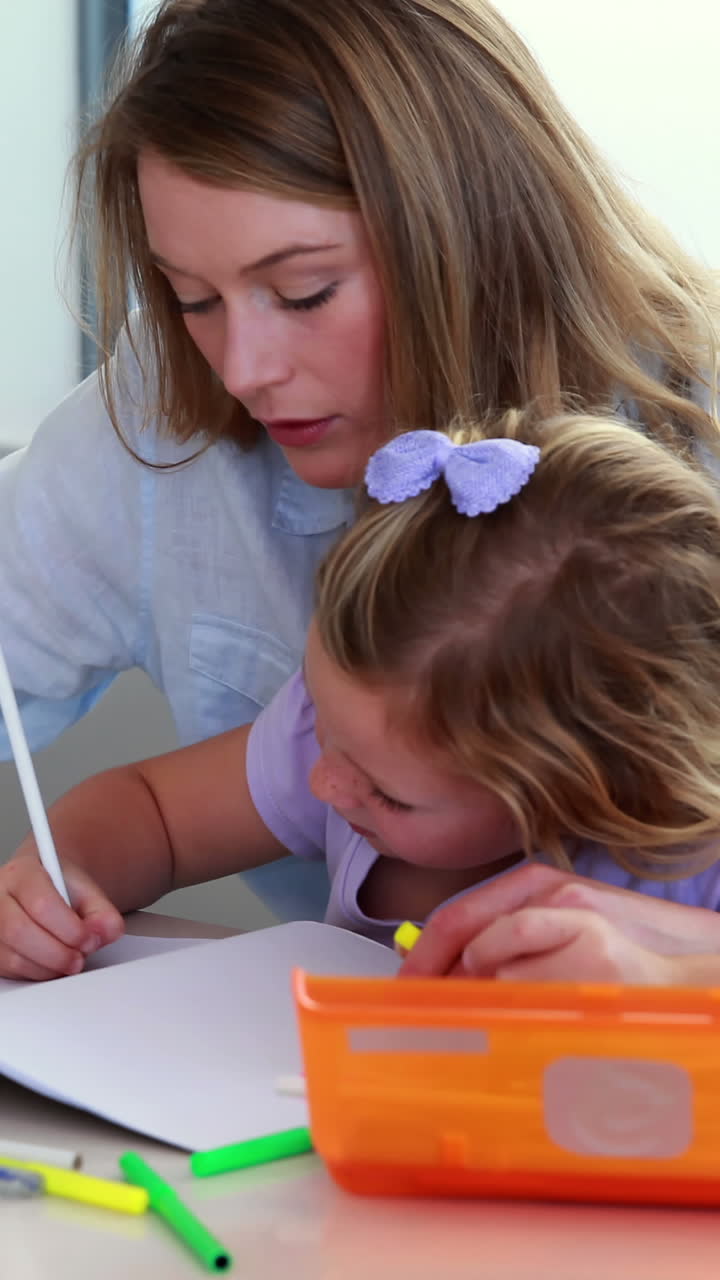 madre e hija dibujando en la mesa