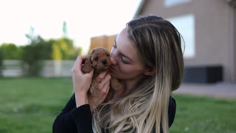 dueña de una mascota sosteniendo y abrazando a un pequeño y lindo cachorro de garabato