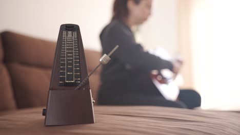 acoustic guitar practice with metronome in focus