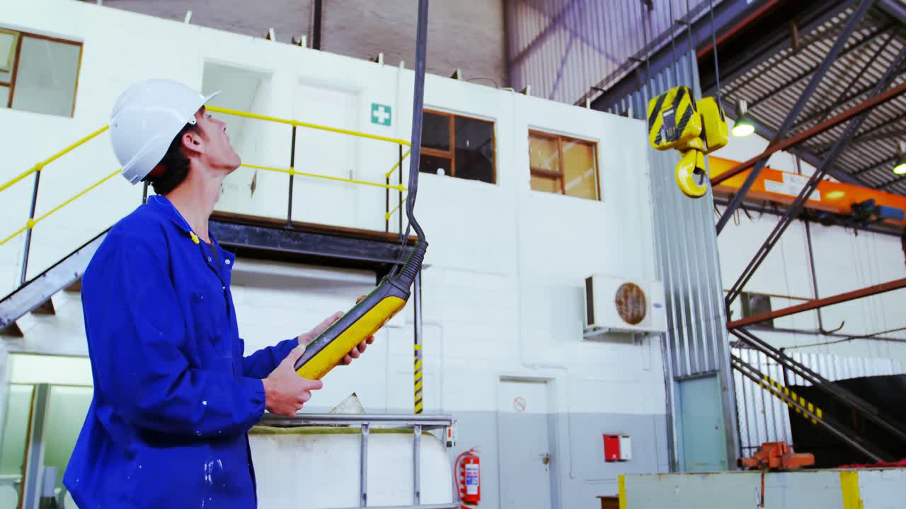 ingeniero masculino que opera una máquina de elevación en el taller 4k