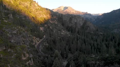 aerial view of a car driving down sonora pass in the sierra nevada mountain range at sunset