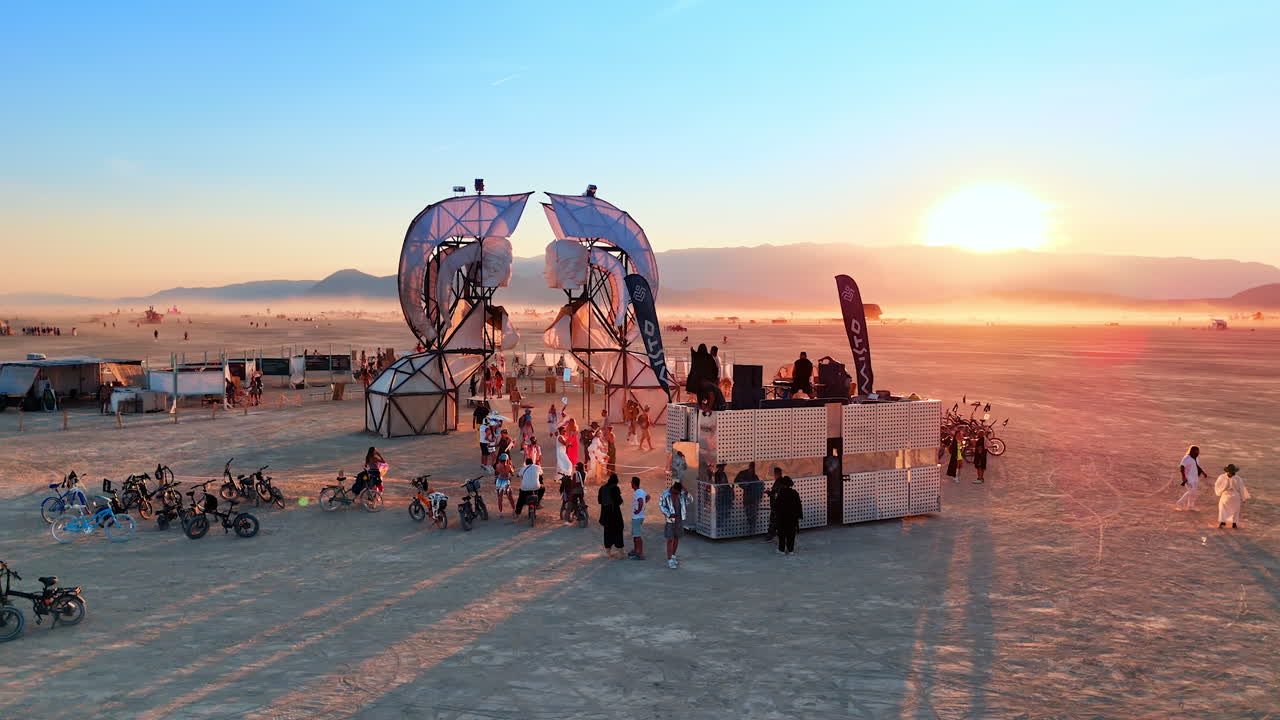 Nevada, USA, 14 August 2025: Wide view of Burning Man art installation and stage in Nevada desert.. An art structure and stage stand in the open playa during the festival. The Nevada desert landscape stretches with mountains in the distance