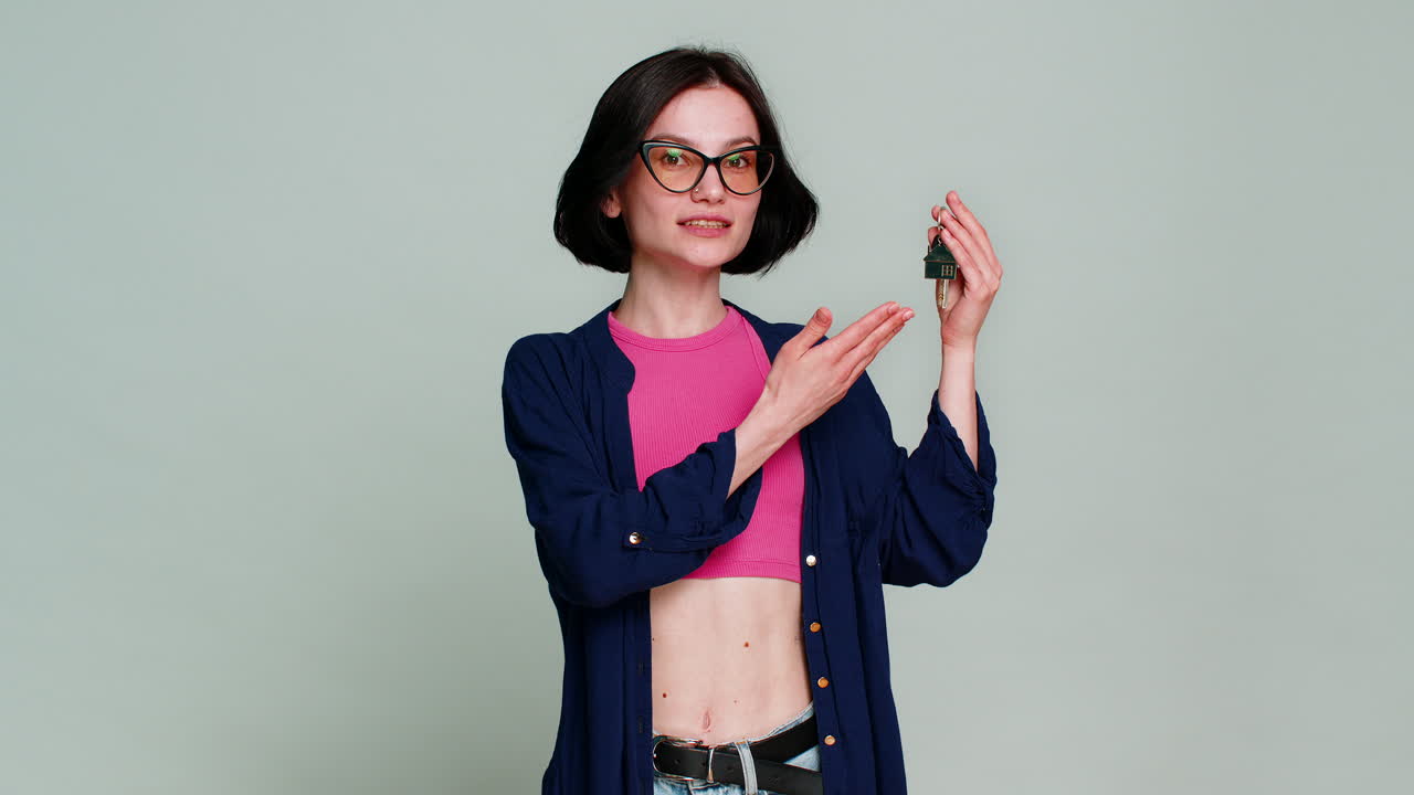 Young happy woman real estate agent showing keys of new home house apartment buying renting property