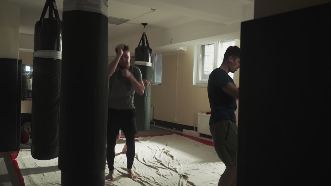 복싱 선수들은 전투 체육관에서 복잡한 운동을 수행합니다. 운동 선수들은 혼합 무술 클럽의 느린 동작에서 스 점프와 공기를 때립니다. 전투 훈련.