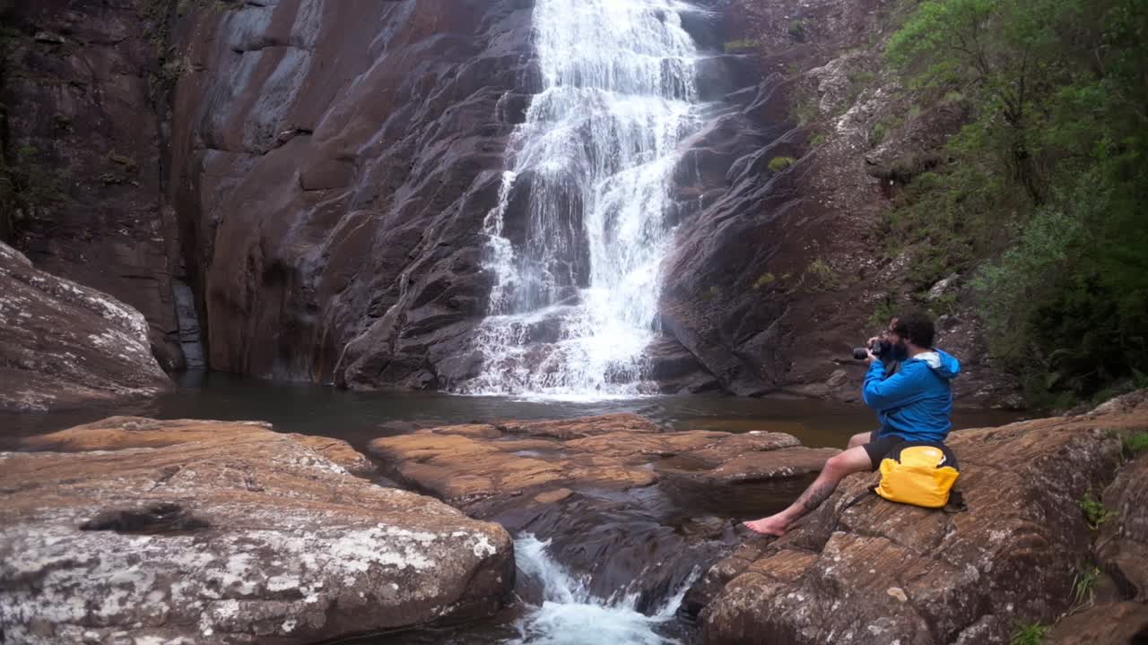 Photographer taking photos of a waterfall, capturing the natural beauty, Minas Gerais, Brazil