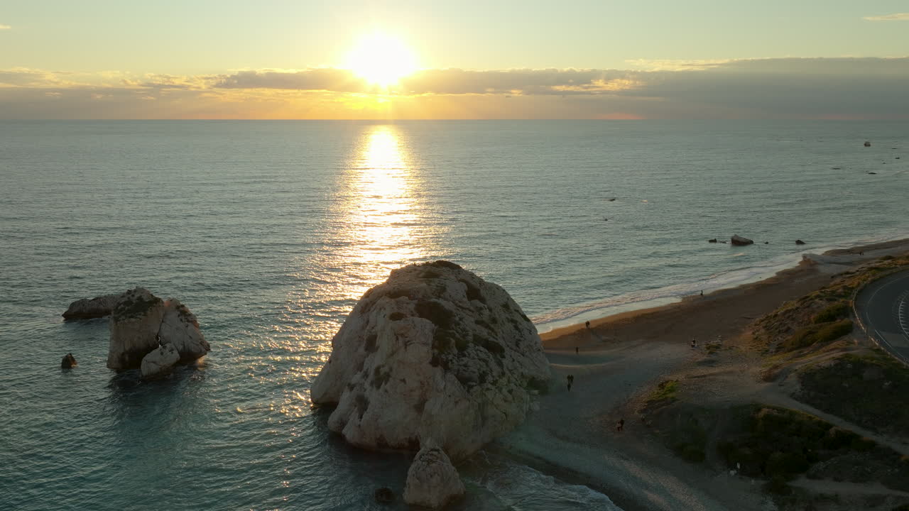 키프로스의 파포스 (paphos) 에서 평온한 바다 지평선 위에 황금빛의 해가 지는 페트라 투 로미우 (petra tou romiou) 또는 아프로디테의 바위의 공중 풍경