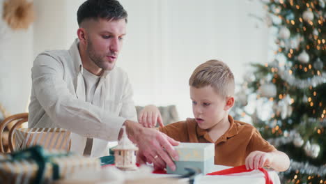 papá enseña a su hijo a envolver regalos