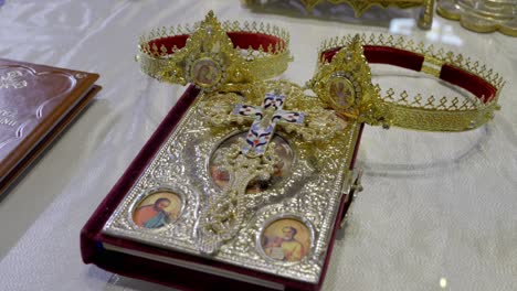 coronas de oro en la antigua biblia santa en el altar durante la ceremonia de boda en la basílica de san nectario en lasi, rumania