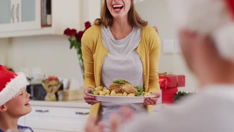 caucasian woman in santa hat serving food to whole family