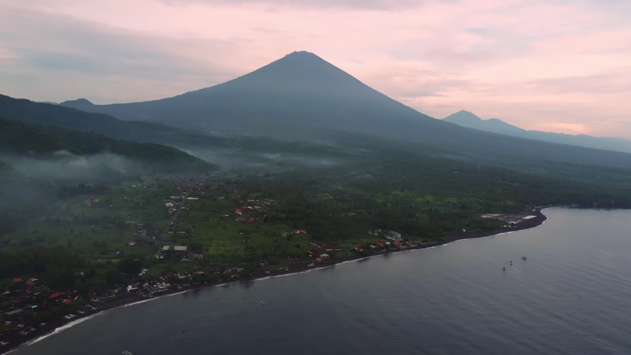 vista aerea amed bali indonesia piccolo villaggio di pescatori sull'oceano con vulcano attivo durante il tramonto colorato