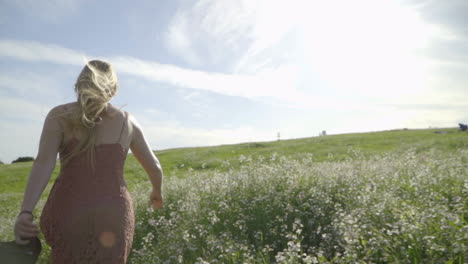 Slomo-Einer-Jungen-Frau,-Die-Durch-Ein-Blumenfeld-Hüpft