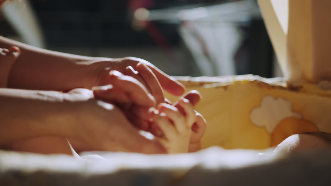 Madre che tiene delicatamente i piedini del bambino