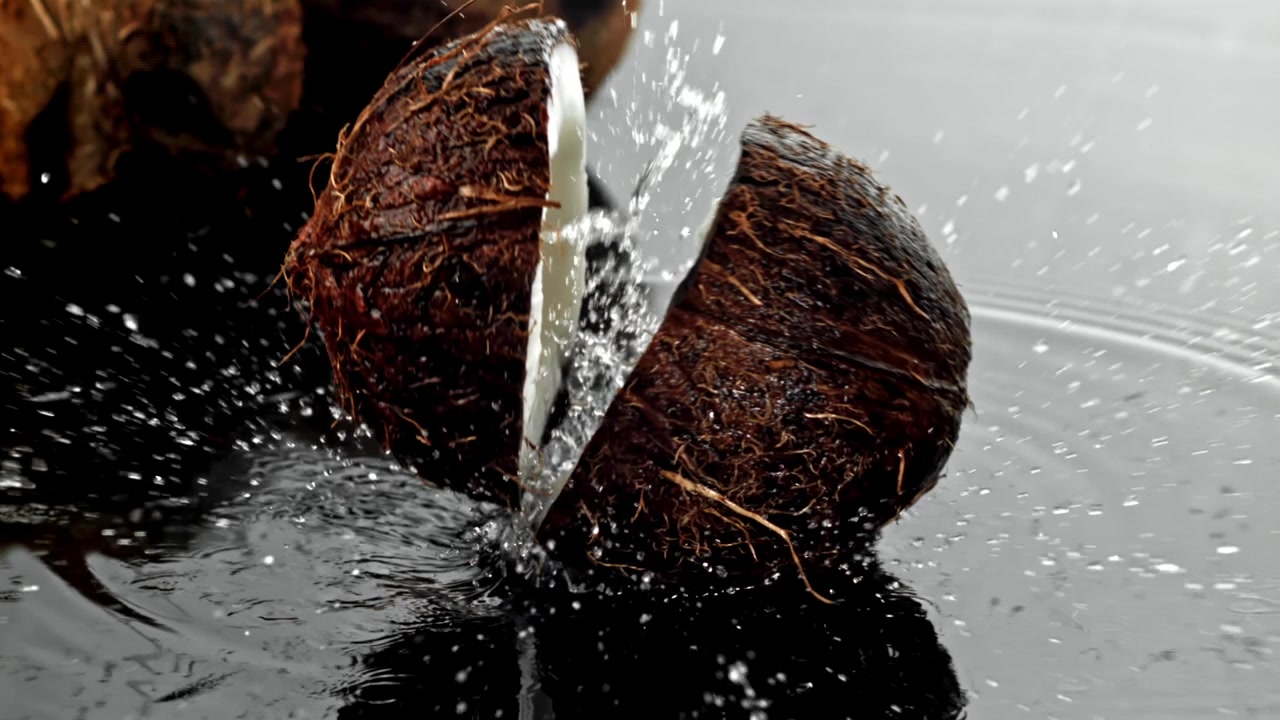 Close-up of Coconut Splitting and Splashing Water in Slow Motion
