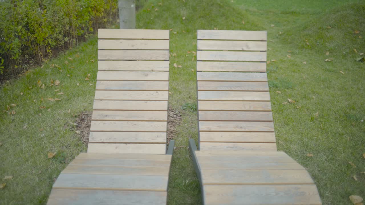 dos sillas de leña de madera en un parque