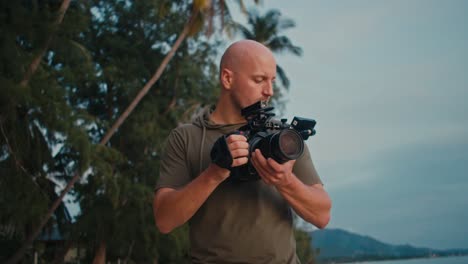 photographer filming on a tropical beach at sunset