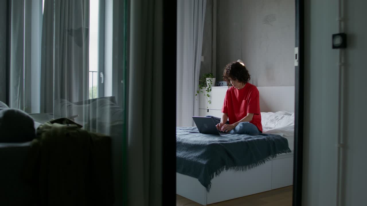 침실에서 노트북으로 일하는 여자