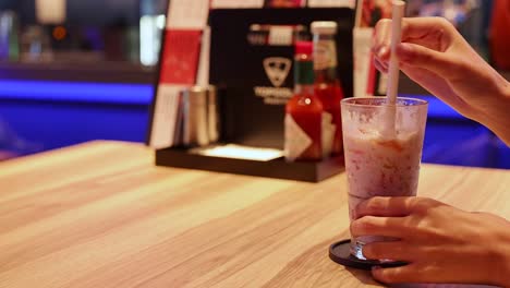 woman enjoying a refreshing fruit drink at a restaurant.