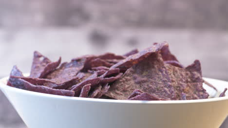 tazón apetitoso de nachos de maíz azul crujientes