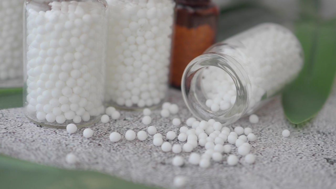 Bottiglie di vetro piene di pillole omeopatiche su una superficie ruvida
