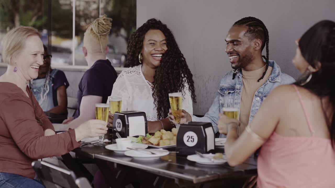 Friends laughing and enjoying drinks at an outdoor cafe
