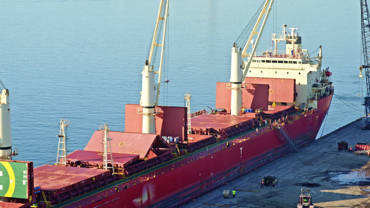Aerial cinematic shot drifting over Detroit River, showcasing both freighter traffic and skyline